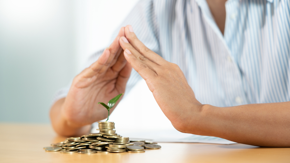 What is savings insurance types and how they work hand,protect,cover,guard,a,young,tree,growing,on,pile